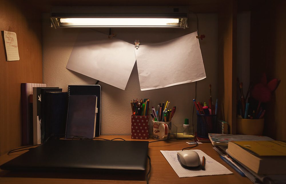 A small working desk under a lamp